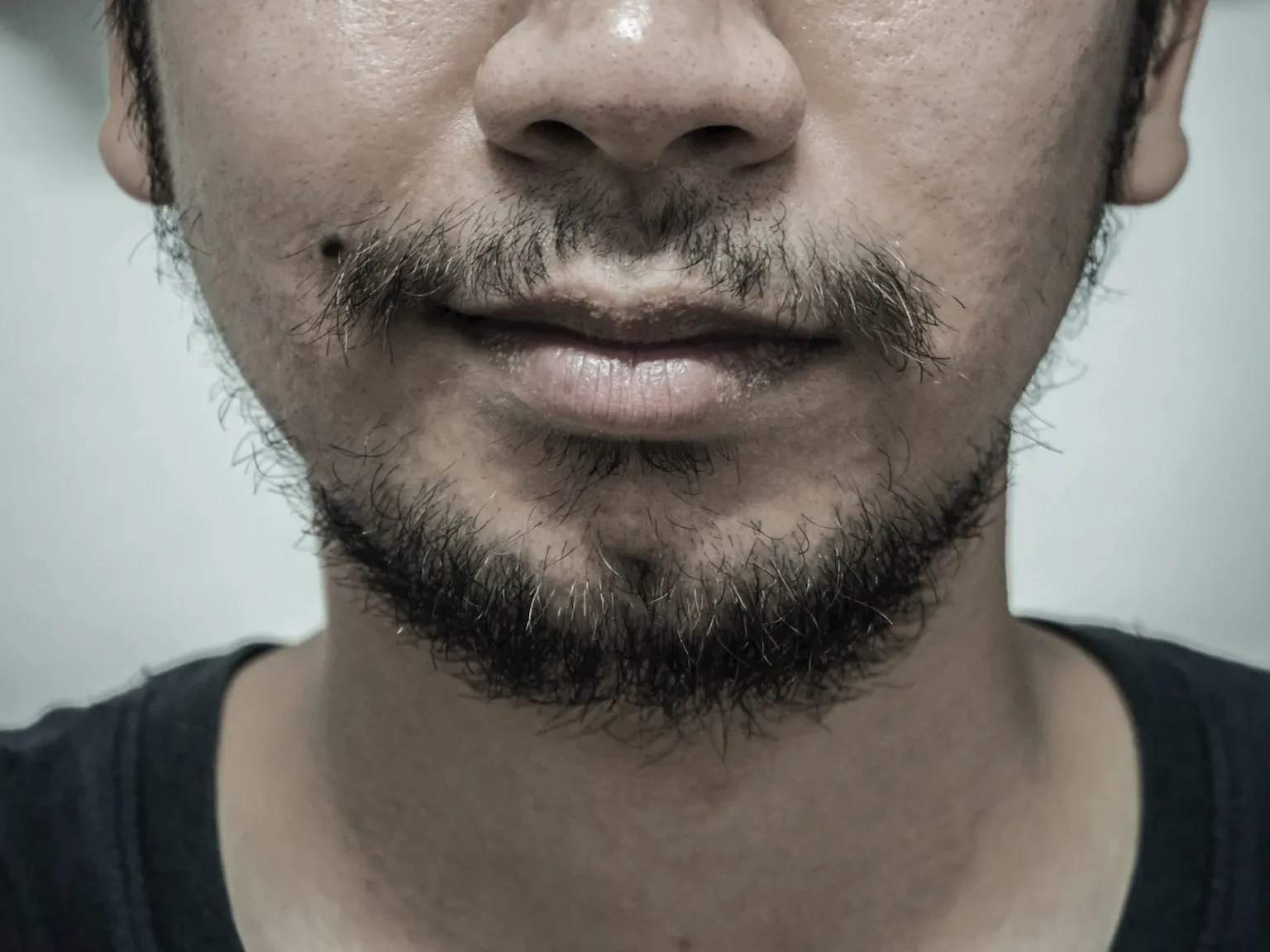 man with patchy beard smiling 2024